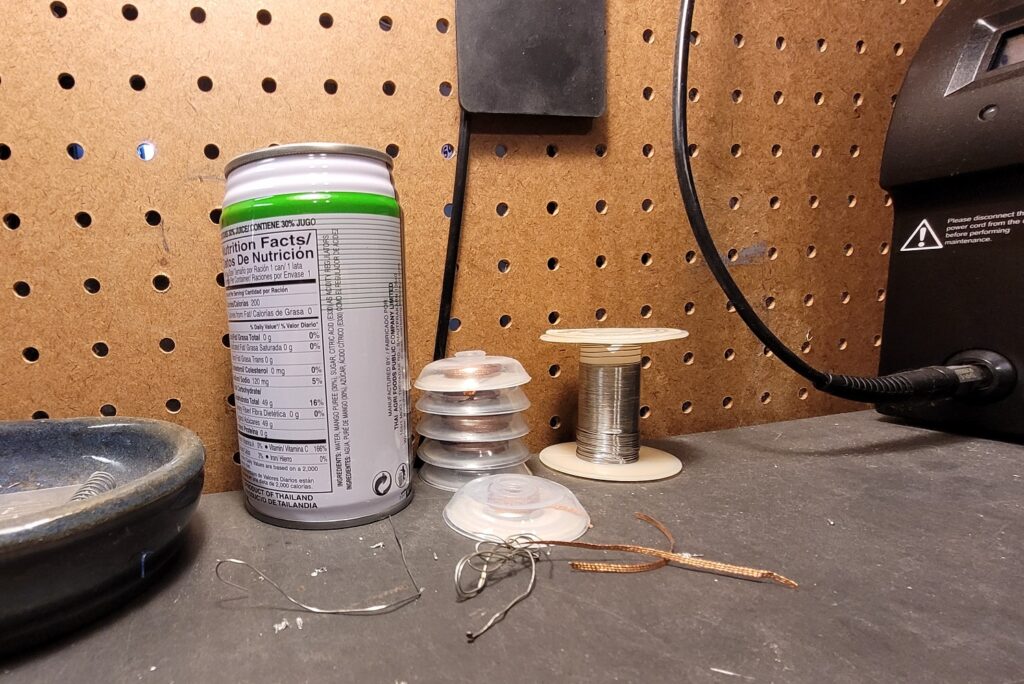 Metal can next to desoldering wick and solder