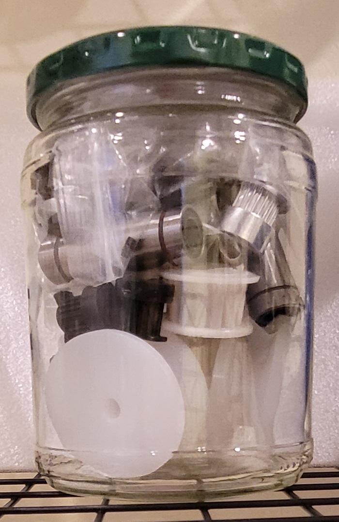 Glass jar containing 
pully wheels, timing pulleys, and bearings